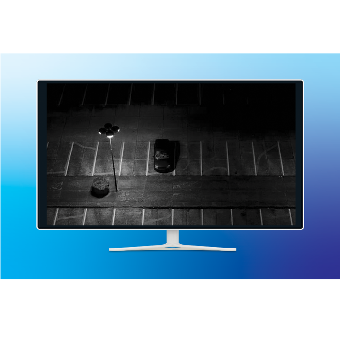A monitor displaying a nighttime camera view of a parking lot.
